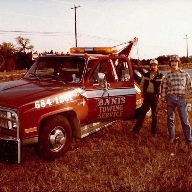old red tow truck parked at the side of the road